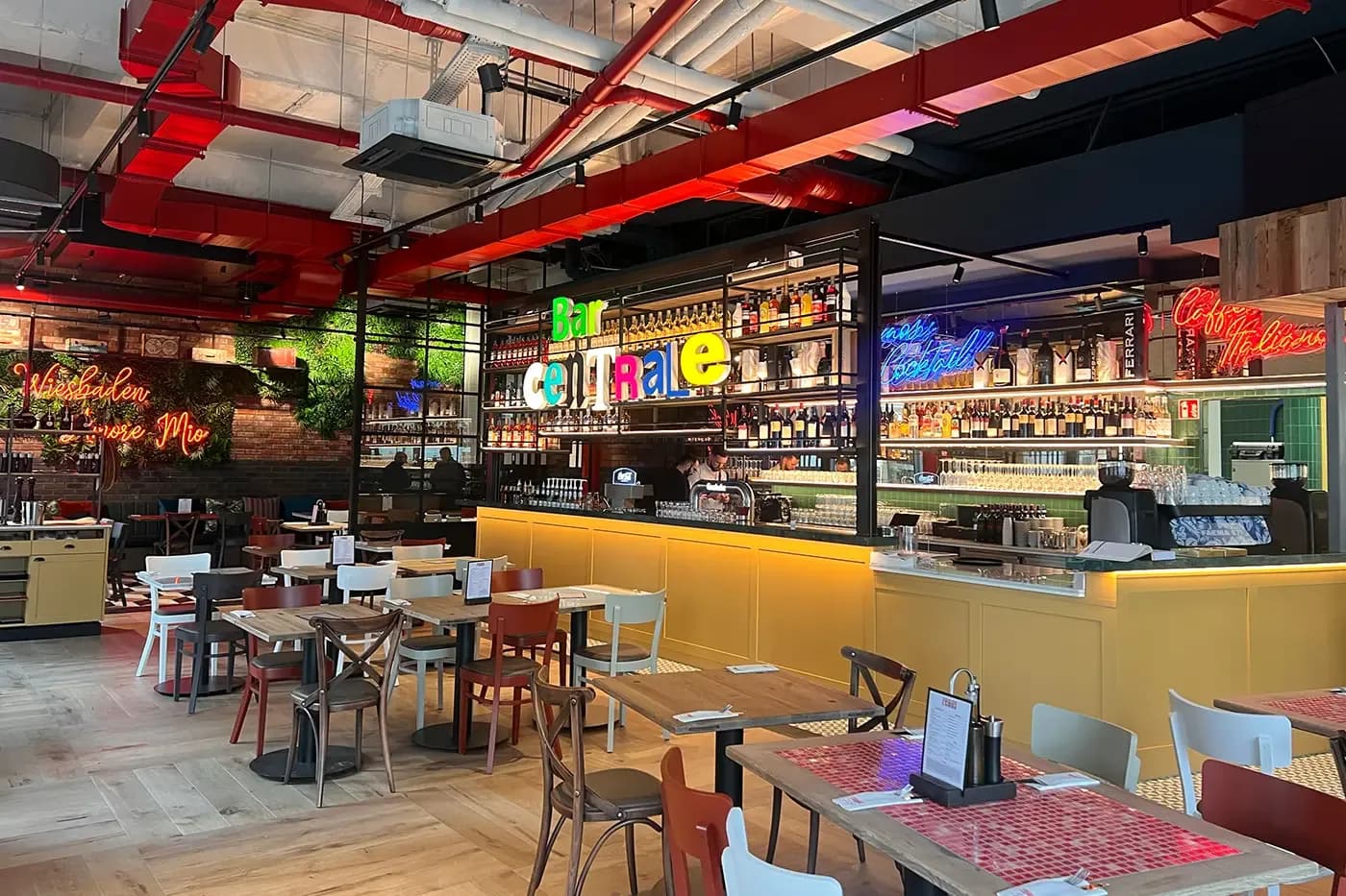 Dining room at remos Wiesbaden with a colourful bar and red pipes